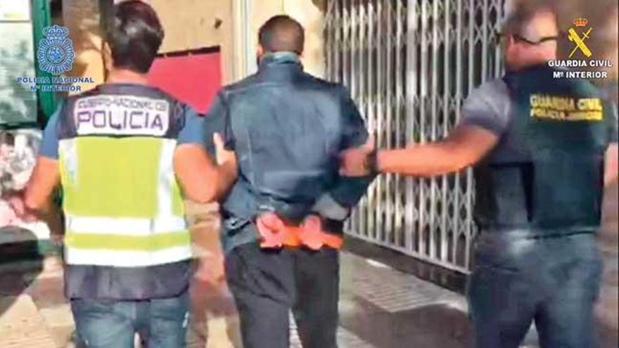 Un policía y un guardia civil trasladan a uno de los tres detenidos por los robos en Eivissa.