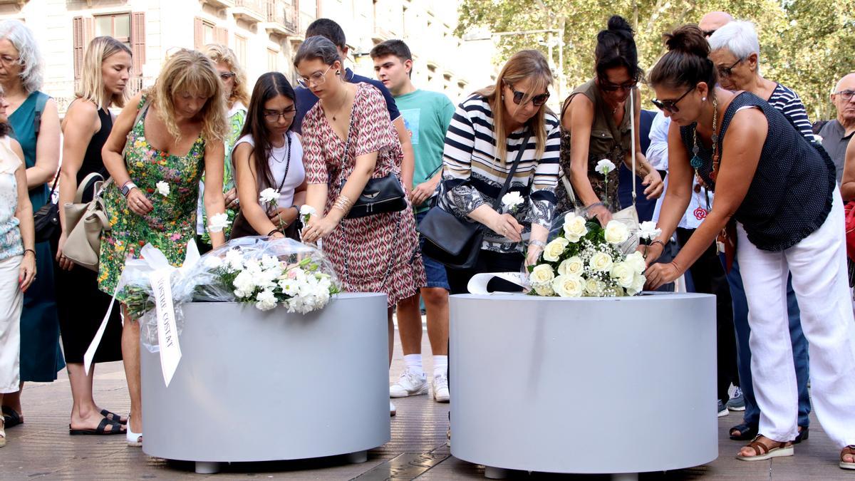 Familiars i víctimes del 17-A dipositen clavells a les jardineres de la Rambla