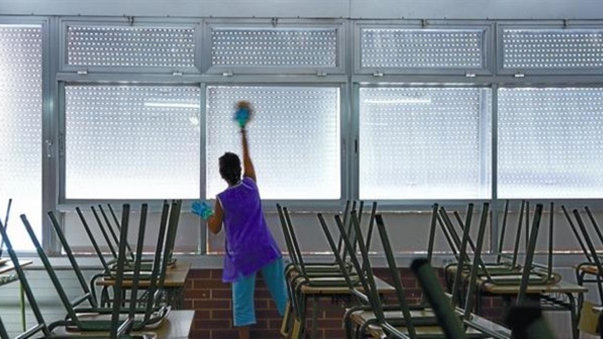 Una trabajadora limpia un aula del colegio Joan Coromines, de Barcelona, ayer.