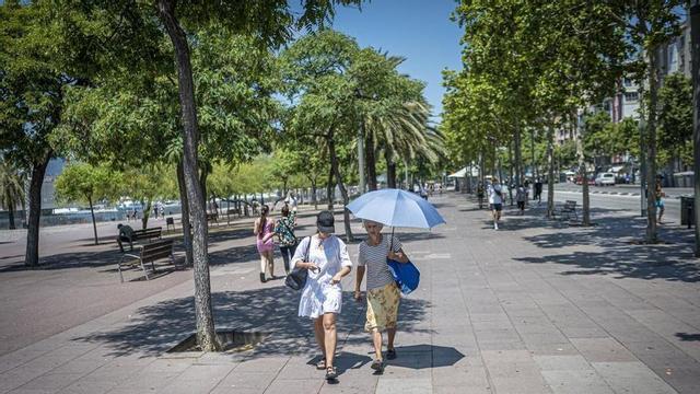 Dues persones passegen sota el sol a Barcelona.
