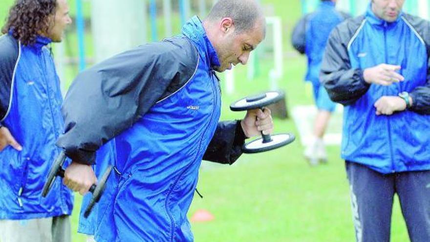 Bravo realiza un ejercicio con pesas en presencia de Curro, a la izquierda,  y del segundo entrenador, Fermín.