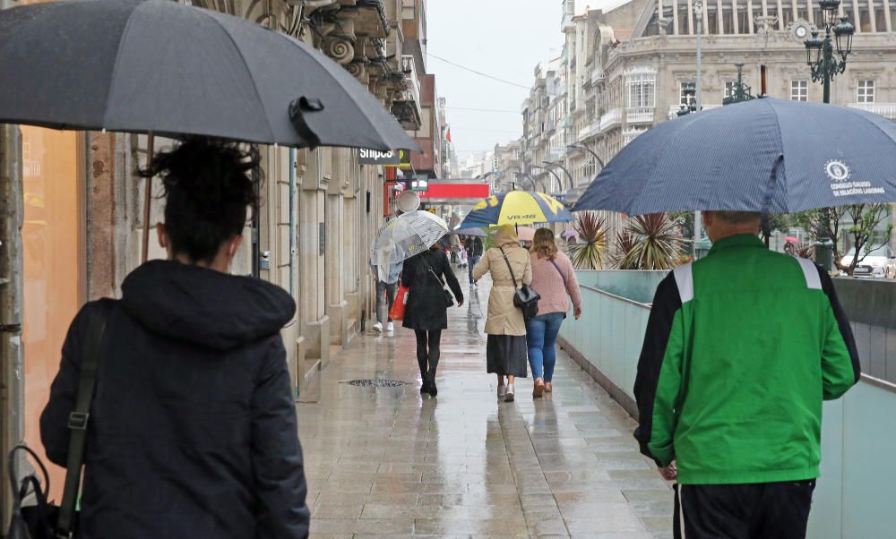 Los viandantes en el centro de Vigo se pertrecharon con paraguas