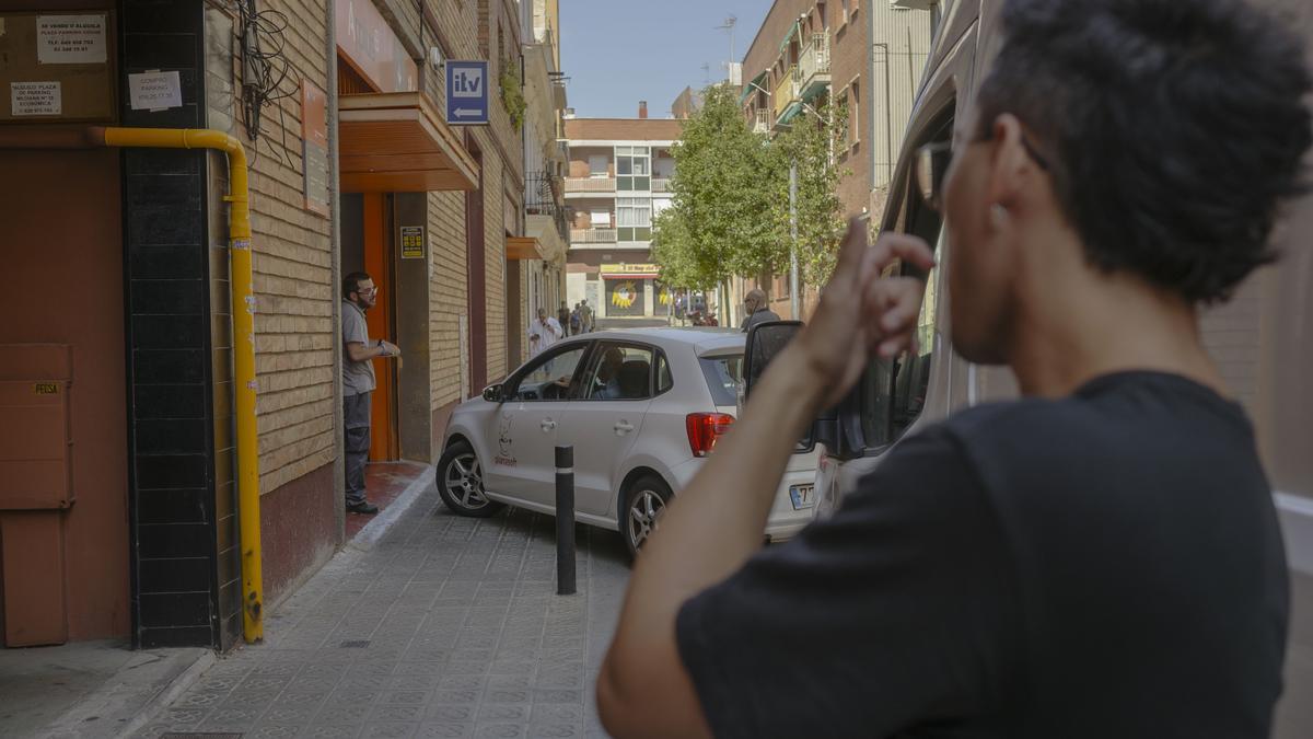 Vehículos haciendo cola en el pasaje Puigmadrona, en Barcelona, para acceder a una estación de ITV.