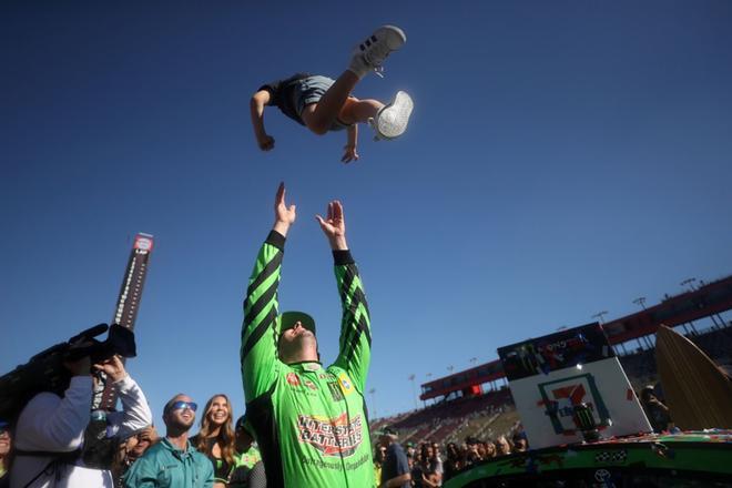 Kyle Busch celebra con su hijo la victoria en la carrera Monster Energy NASCAR Cup Series Auto Club 400 en el Auto Club Speedway en Fontana, California.