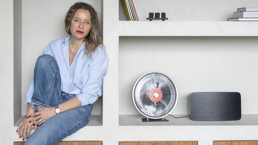 Elena Hinrichs, sobre una estantería diseñada por ella misma y fabricada con material reciclado. | LOC