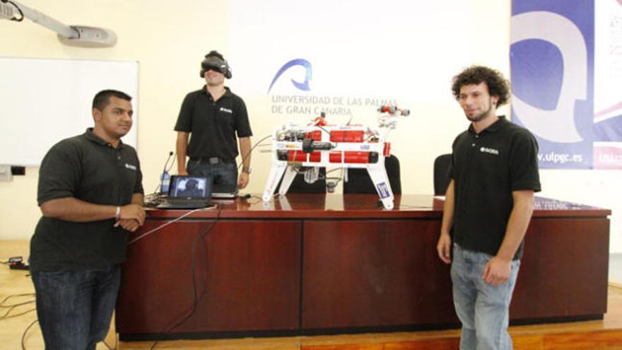 Anil Mahtani (i), David Morales (c) y Luis Sánchez (d) con el robot. | l. del rosario