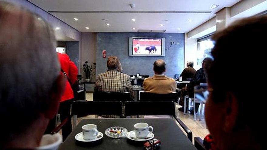 Turistas de Benidorm viendo la televisión en un establecimiento hotelero de la localidad, una actividad por la que el empresario ha de pagar una tarifa.