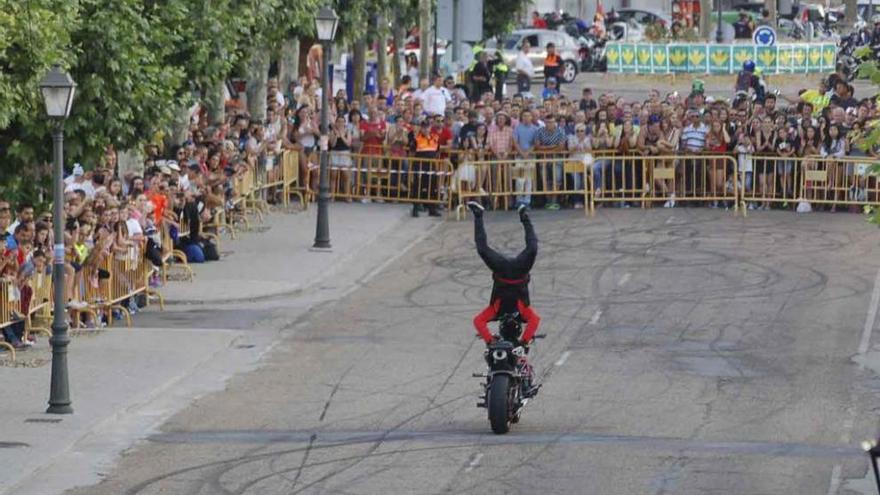 Un profesional realiza piruetas sobre la moto ante gran número de espectadores.