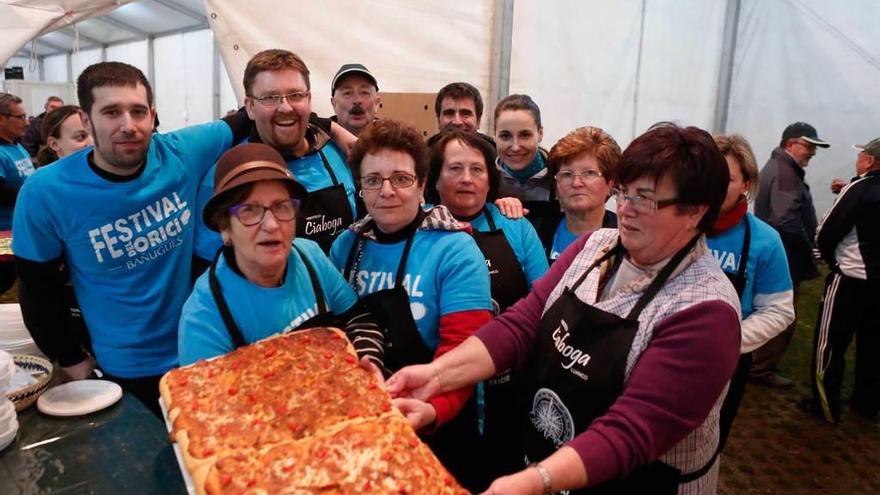 Los organizadores del festival posan con una pizza hecha a base de oricios.