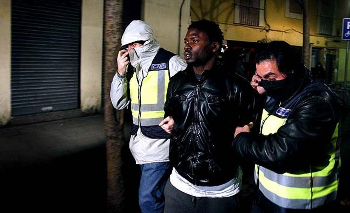 Dos policies detenen un dels implicats en l’operació contra el terrorisme islamista que ha tingut lloc la nit passada al barri del Raval (Barcelona).