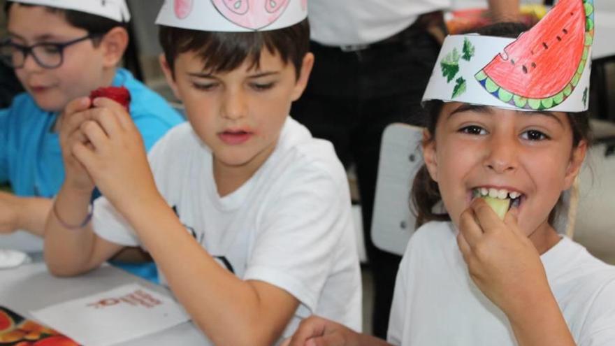 Escolares disfrutando de fruta en el comedor escolar.