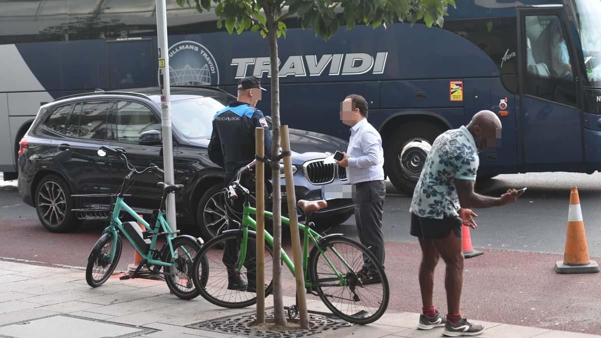 Un agente conversa con el conductor del vehículo, junto a la bicicleta y el ciclista accidentado.