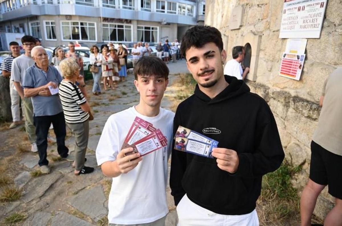 Dos aficionados posando con su entradas