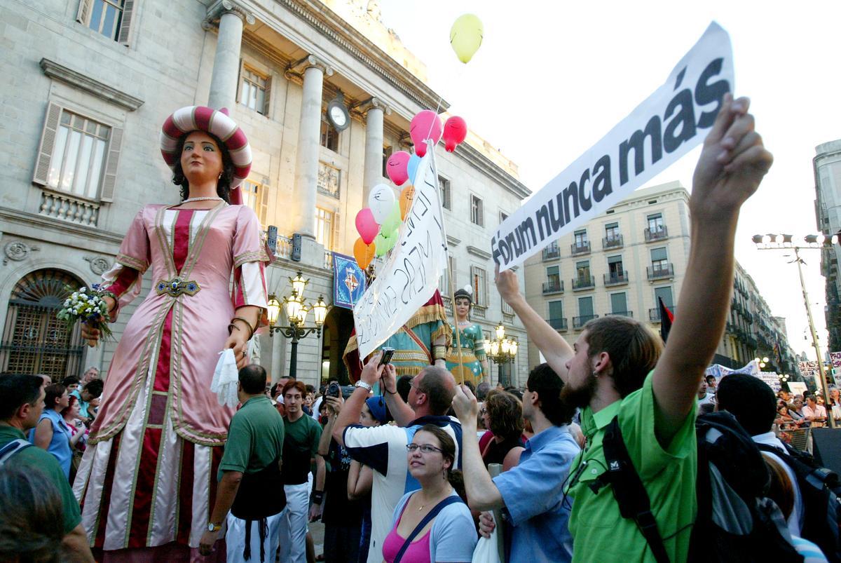 Mercè 2004. PROTESTA DE GRUPOS ANTIFORUM EN LA PÇA SANT JAUME DURANTE LA LECTURA DEL PREGON DE CARLOS RUIZ ZAFON Y JOAN CLOS