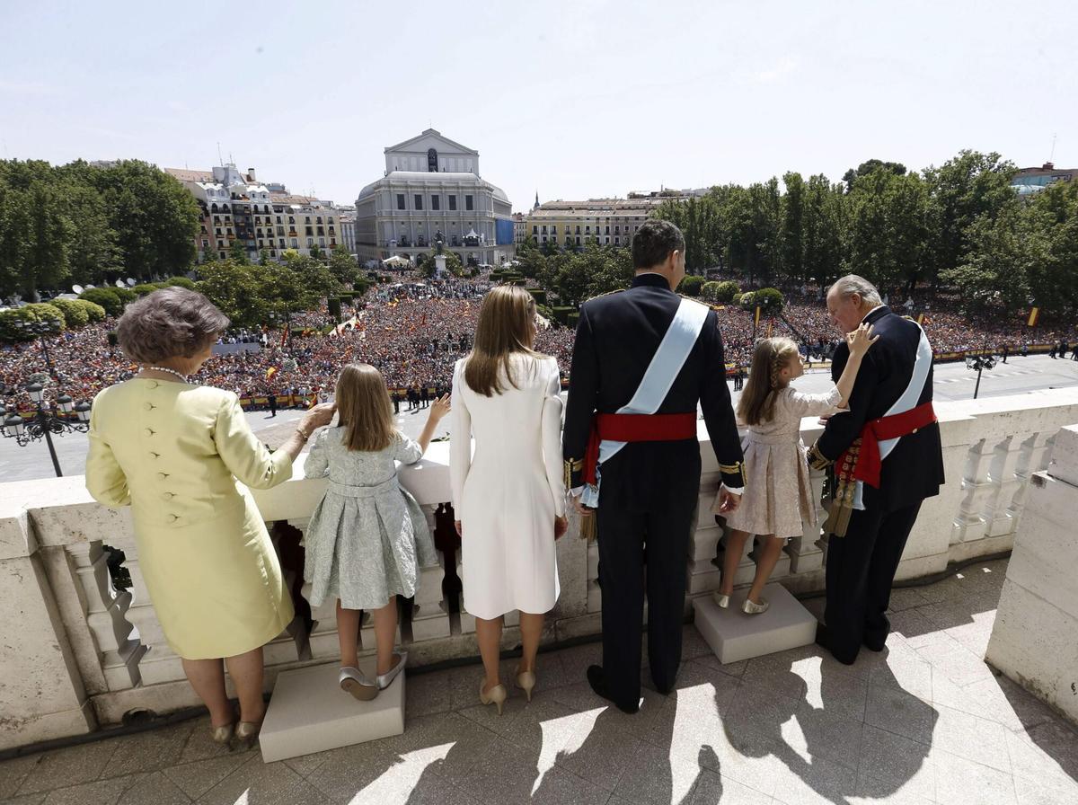 MADRID, 19/06/2014.- Los reyes, Felipe VI y Letizia, junto a sus hijas, Leonor, princesa de Asturias, y la infanta Sofía, y don Juan Carlos y doña Sofía, saludan desde el balcón central del Palacio de Oriente a los ciudadanos que se han congregado para rendirles homenaje, tras el acto de proclamación celebrado en el Congreso de los Diputados. EFE/Javier Lizón ***POOL*** NO VENTAS LOS REYES SALUDAN AL PUEBLO DESDE EL PALACIO REAL. MONARQUIA ESPAÑOLA. CORONA. CORONACION. FAMILIA REAL ESPAÑOLA. PROCLAMACION. MAJESTAD. REY FELIPE VI