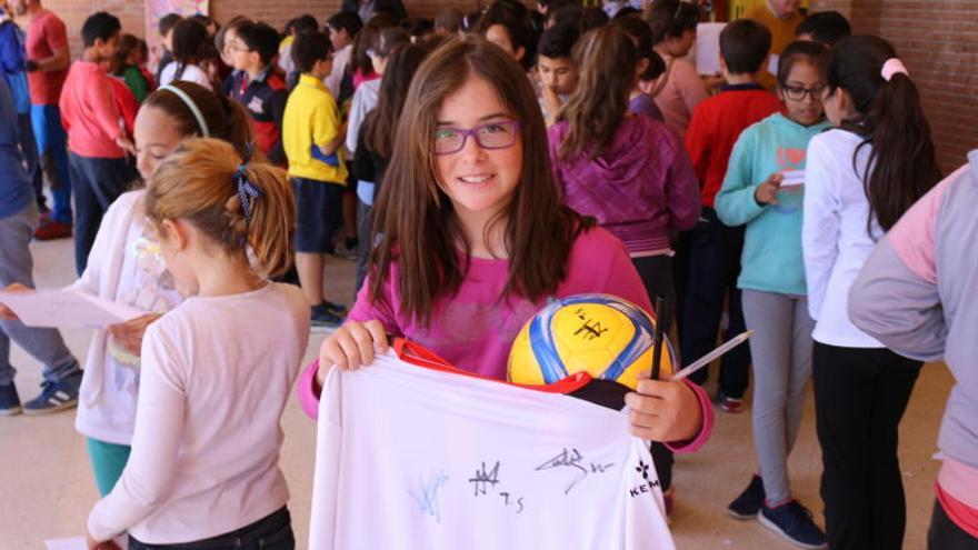 Una niña muestra la camiseta firmada por los jugadores