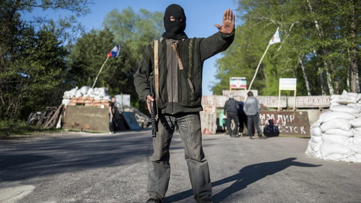 Un rebelde prorruso bloquea el paso en un punto de control en Donetsk.