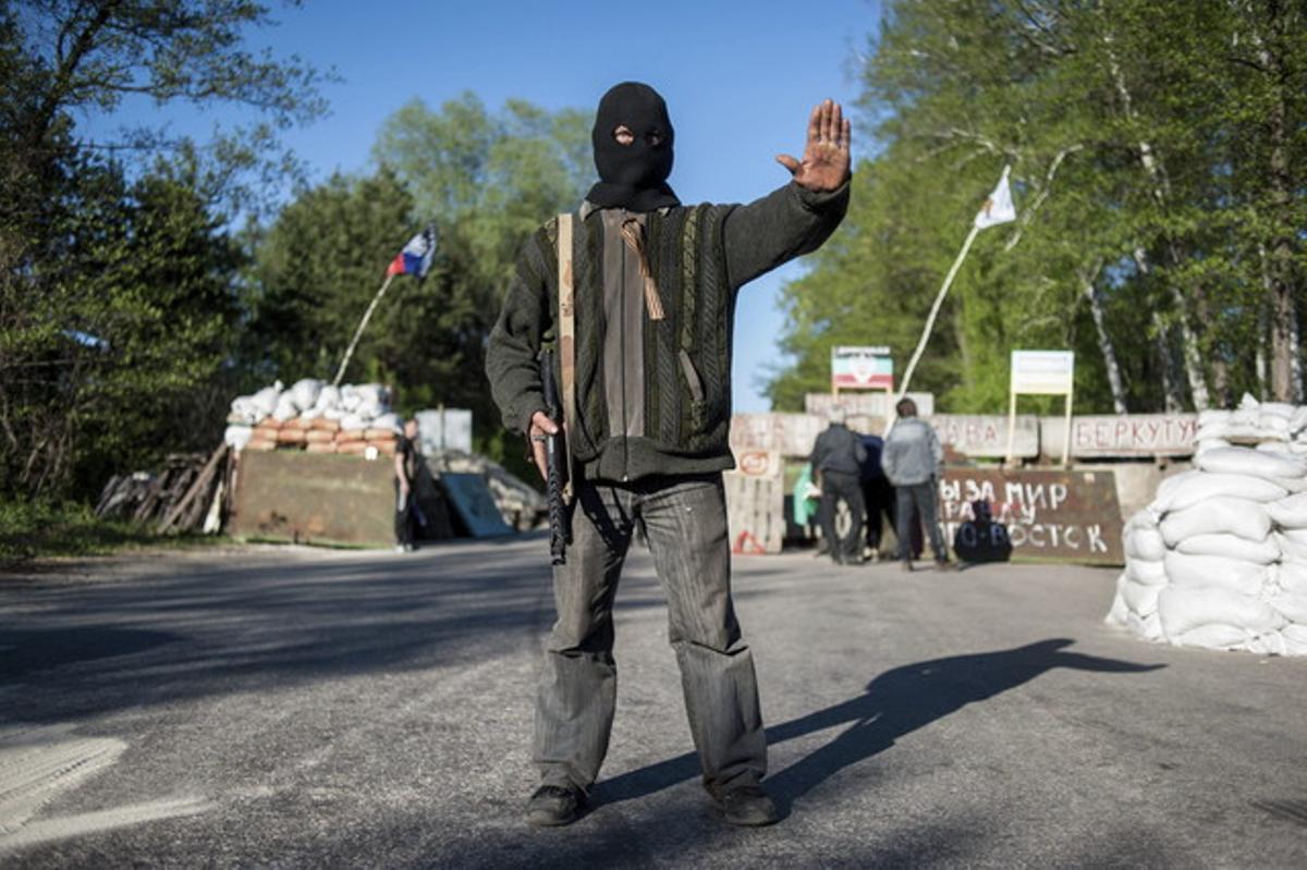 Un rebel prorús bloqueja el pas en un punt de control a Donetsk. Un rebel prorús bloqueja el pas en un punt de control a Donetsk.
