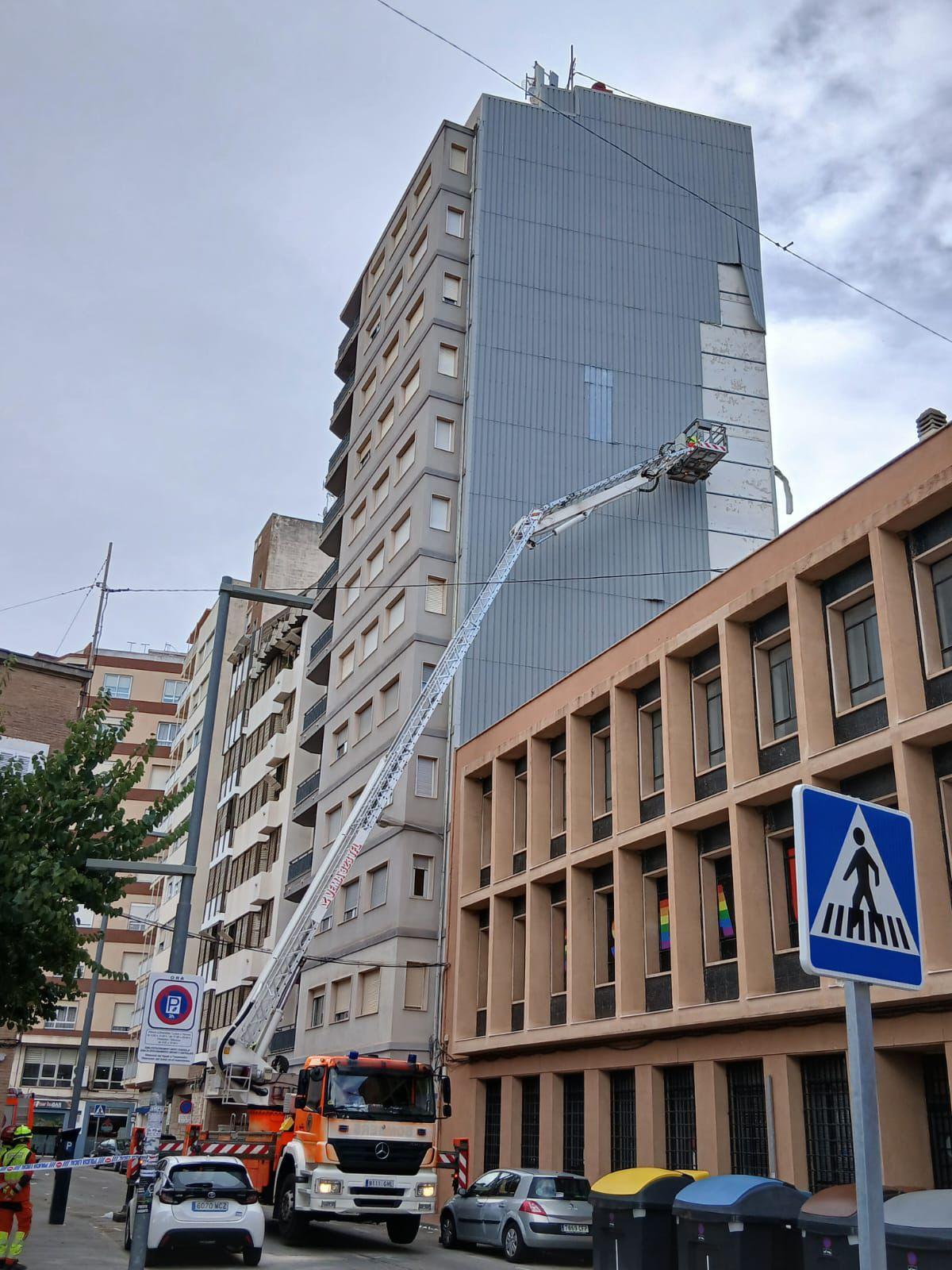 Los bomberos, al intervenir en la finca de la que se desprendieron placas metálicas.