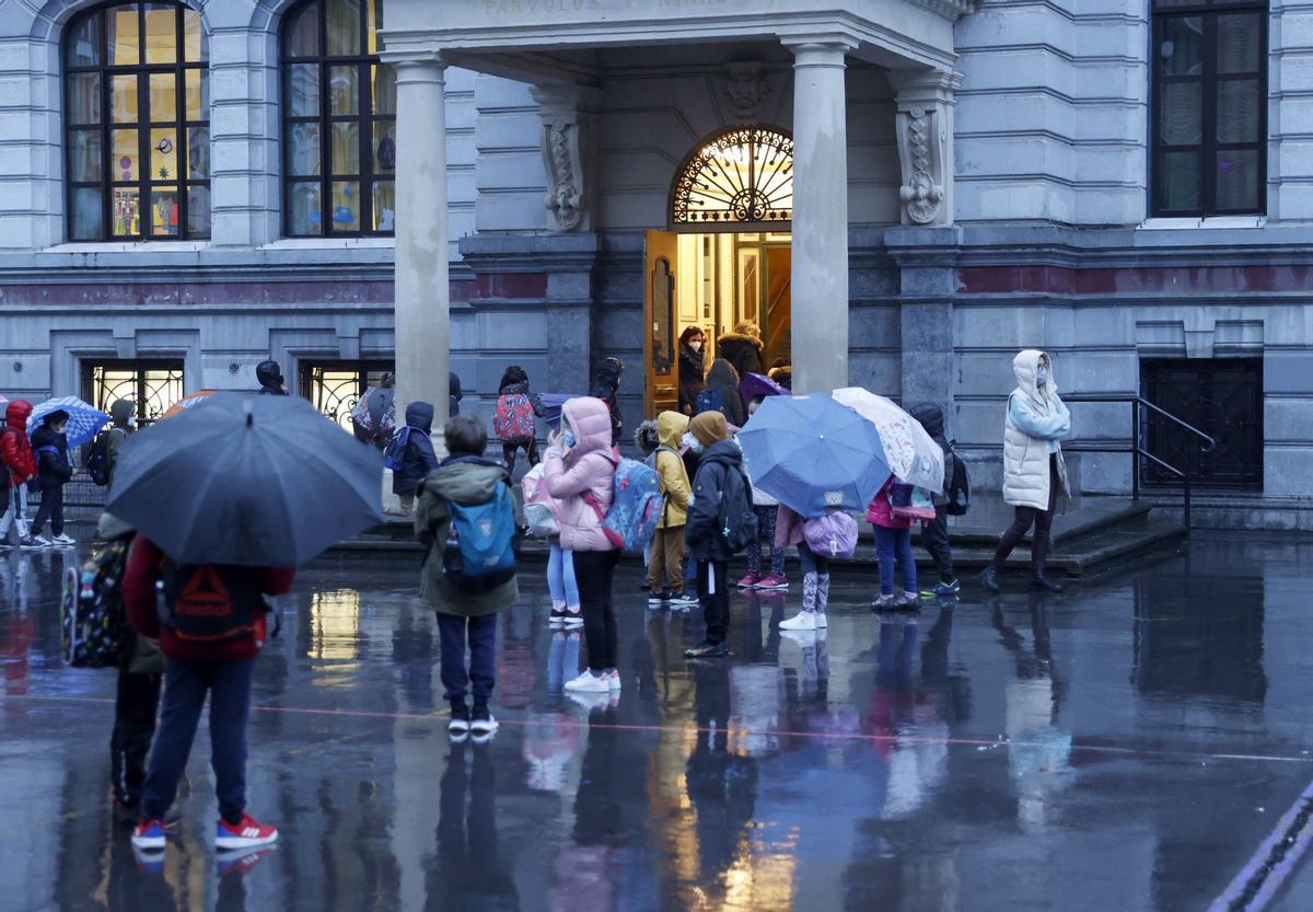 Una profesora asiste a los alumnos durante la entrada a un colegio este lunes en Bilbao tras las vacaciones navideñas.