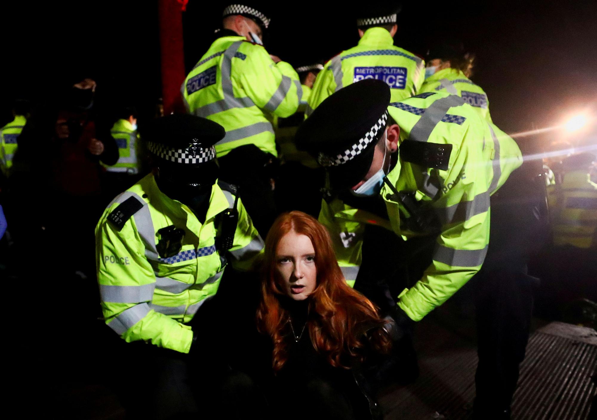 Dos agentes detienen, el 13 de marzo en Londres, a una mujer en una protesta por la muerte de Sarah Everard, violada y asesinada por un policía.