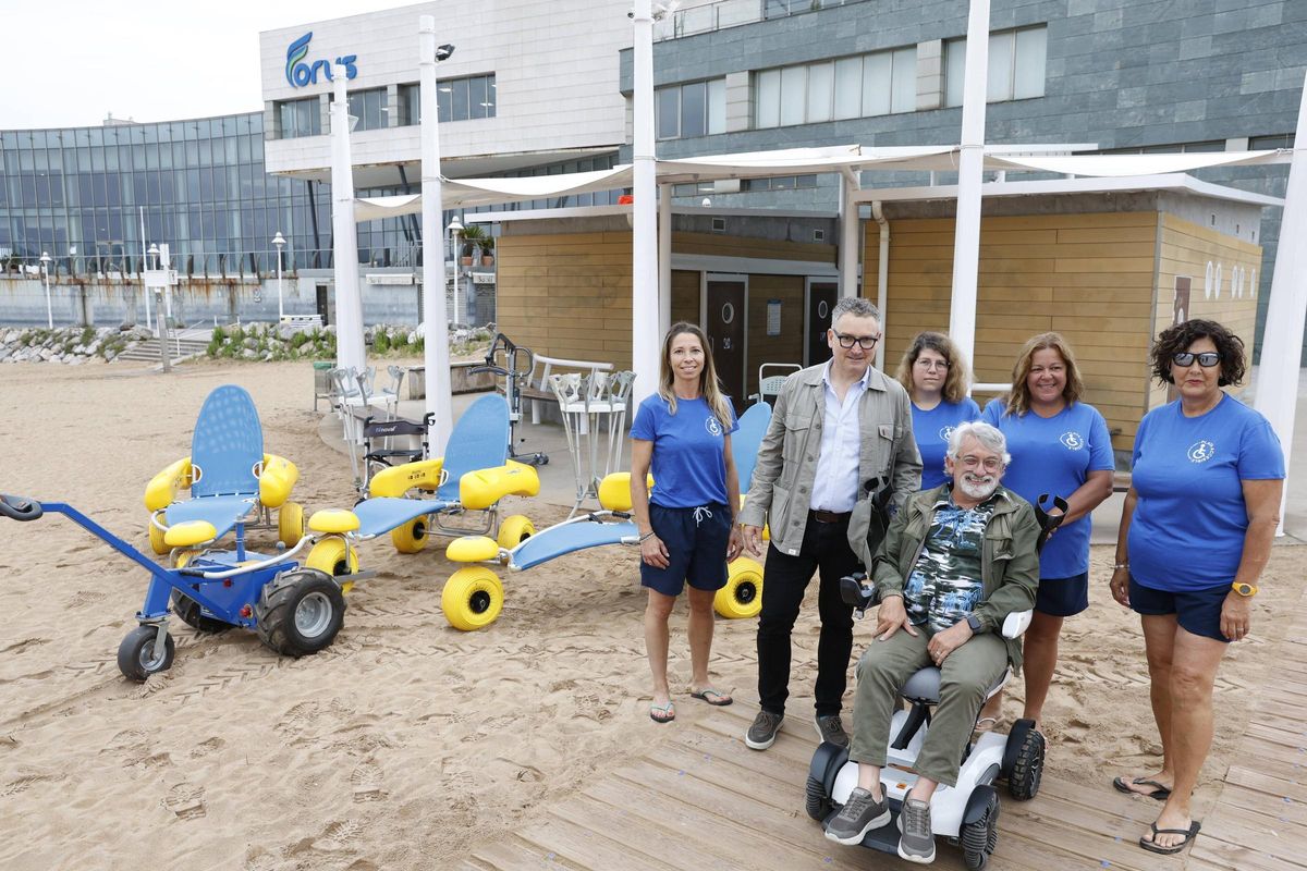 Por la izquierda, Silvia Vigil, Gilberto Villoria, Belén Fernández, Alejandro Catraín, Mónica Sánchez y Beatriz Menéndez, ante el edificio y material del servicio de playa accesible, en la playa de Poniente de Gijón.