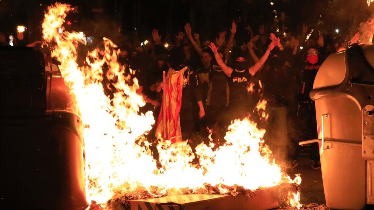 Manifestantes quemando contenedores.