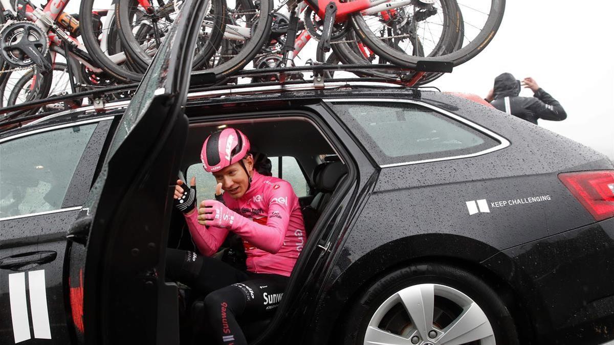 TOPSHOT - Team Sunweb Netherlands  rider Wilco Kelderman  wearing the overall leader Pink Jersey  gives the thumbs up as he gets in his team car to be transported to a bus following negotiations about the lenght of the route and changes in today s stage during the 19th stage of the Giro d Italia 2020 cycling race  a 258-kilometer route between Morbegno and Asti on October 23  2020  - A delegation of riders talked on October 23  2020 for about twenty minutes with the director of the Giro presenting the group s protest for the excessive length of the stage  also characterized by cold and rain   The negotiation between the runners and the race management led to the decision to shorten the first 100 kilometers  which will be covered by the teams by bus  After the initial walkway from Morbegno  the teams will therefore head in the direction of the buses and will return by bike only to tackle the last 158 km towards Asti  (Photo by Luca Bettini   AFP)