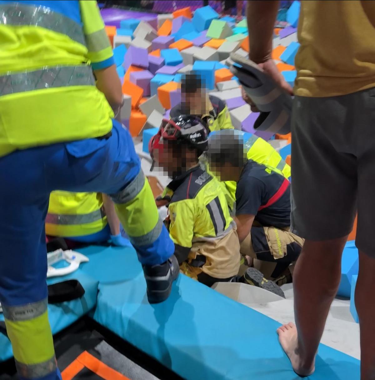 Los bomberos atienden a una persona que resultó lesionada en una colchoneta del parque.