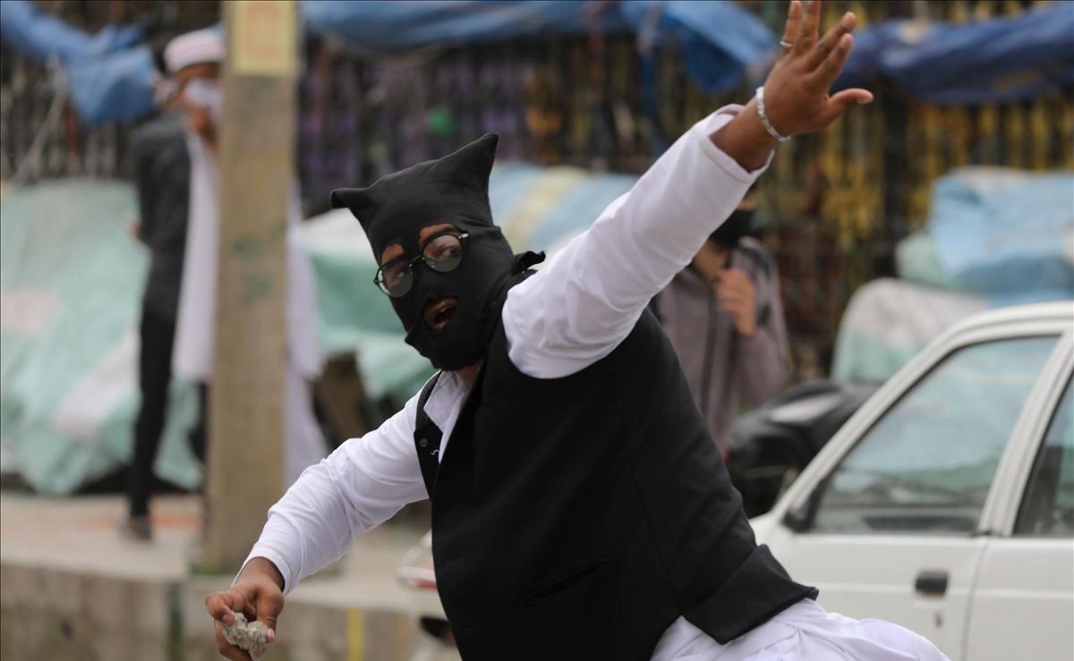 Un musulmán cachemir tira piedras a la policía india durante una protesta tras los rezos del viernes en la mezquita de Jamia Masjid, en Srinagar, capital estival de la Cachemira india.