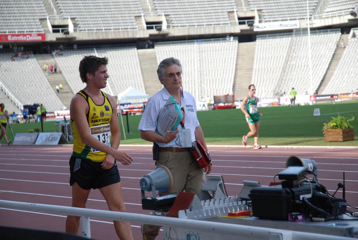 Iglesias, a la derecha, junto a un atleta en el estadio olímpico de Montjuic.