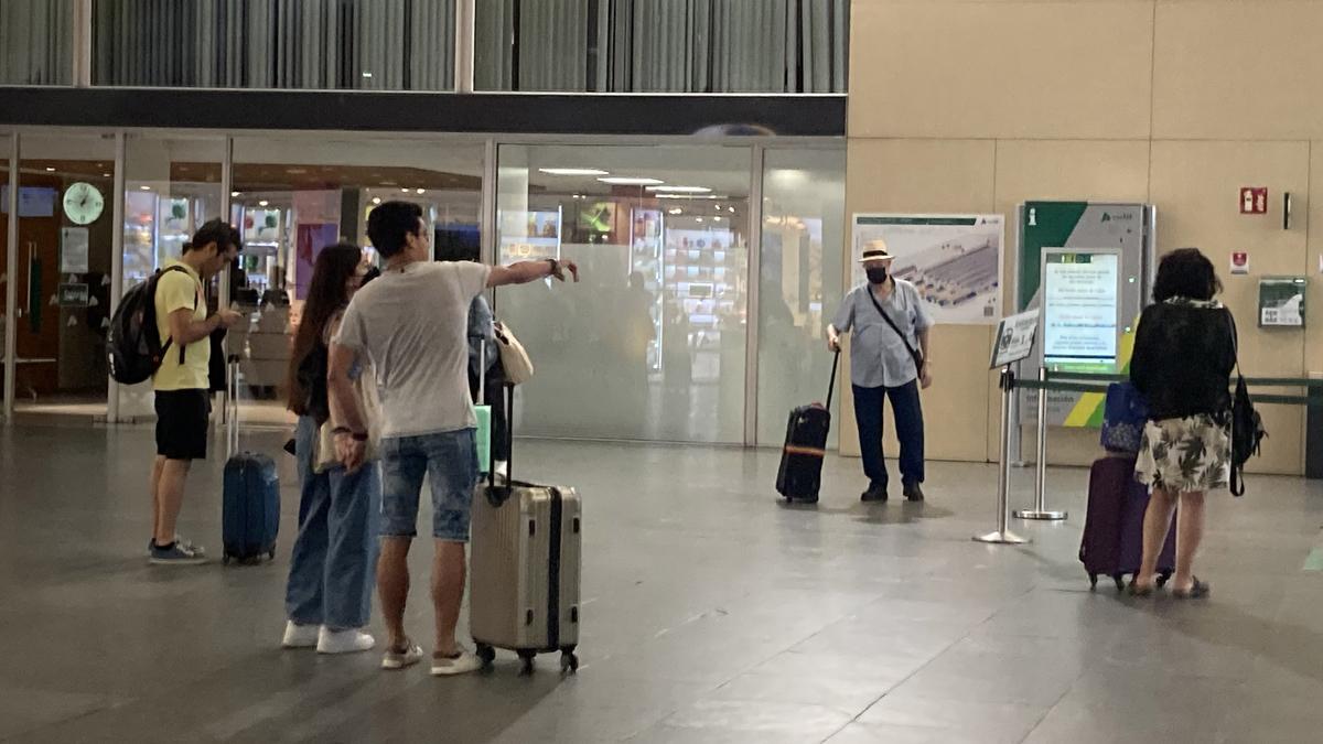 Varios viajeros, con maletas, en la Estación Delicias.