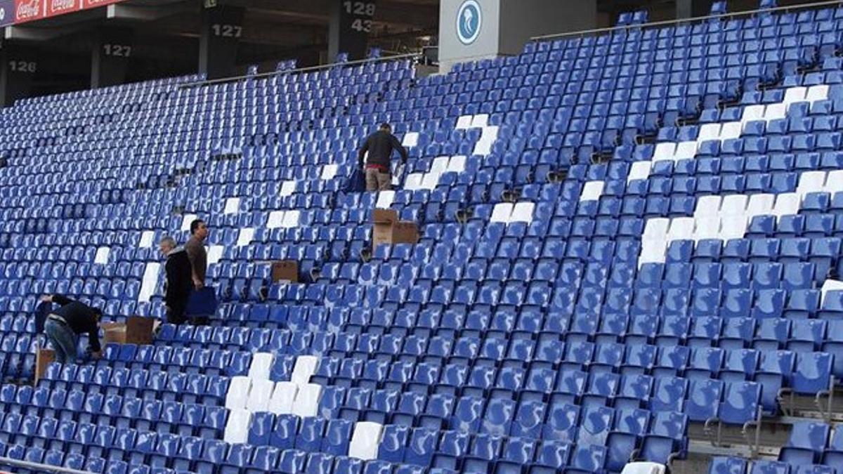 Trabajadores retirando publicidad de Power8 del estadio