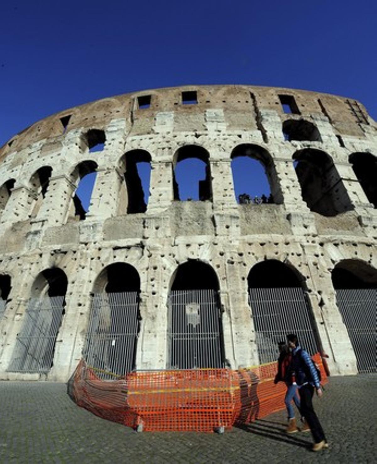 Dues turistes passen al costat de la zona acotada pels bombers després del despreniment d’una part del Colosseu romà, dilluns passat. Dues turistes passen al costat de la zona acotada pels bombers després del despreniment d’una part del Colosseu romà, dilluns passat.