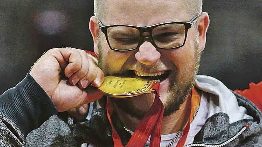 Pawel Fajdek muerde su medalla de oro. // Efe