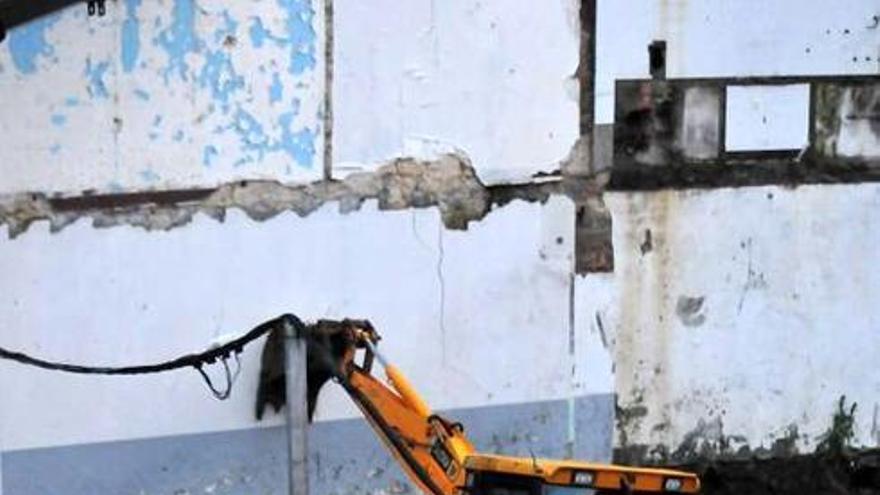El solar en obras y la vivienda afectada.