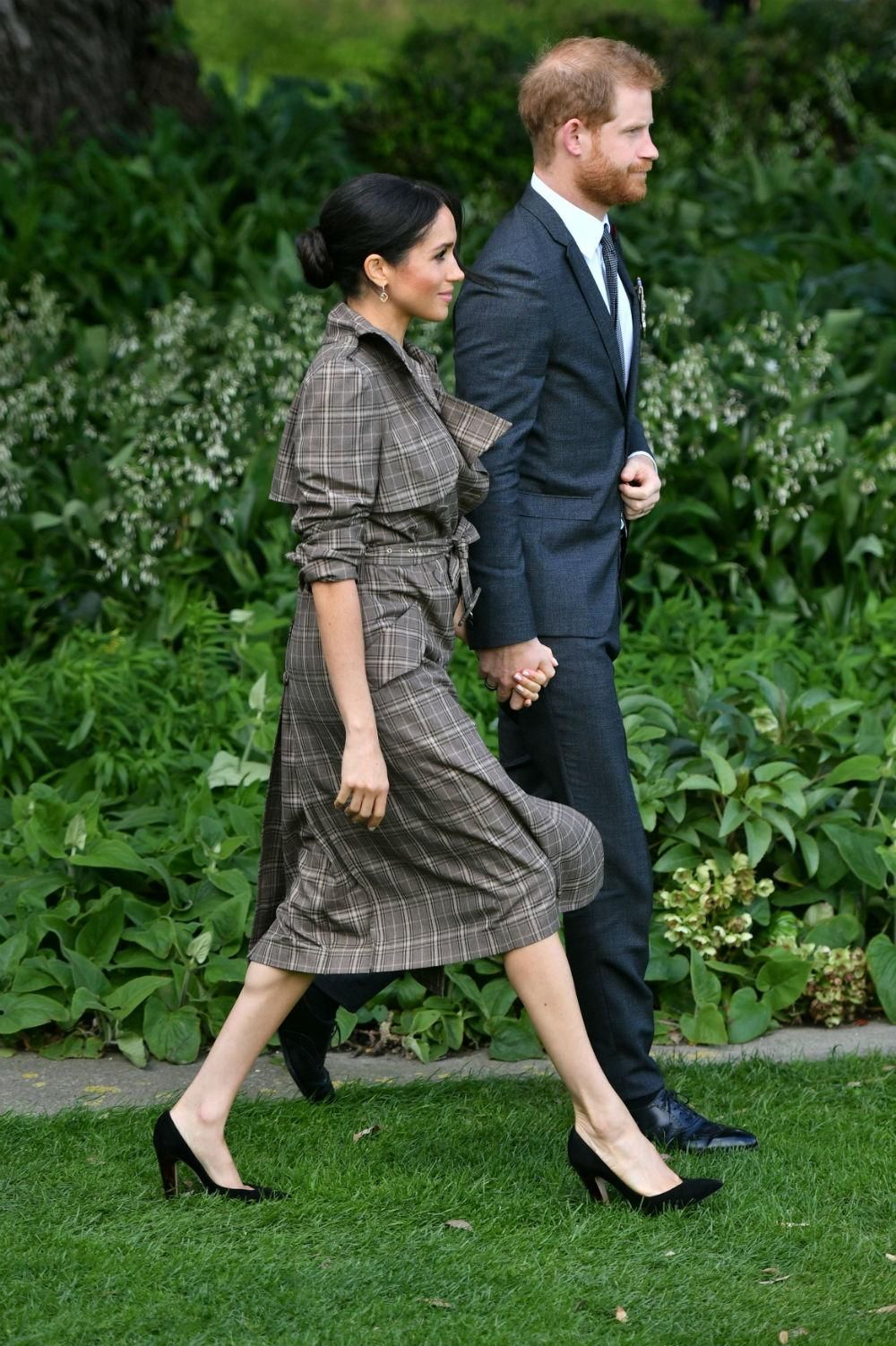 Meghan Markle con gabardina de Karen Walker junto al Príncipe Harry