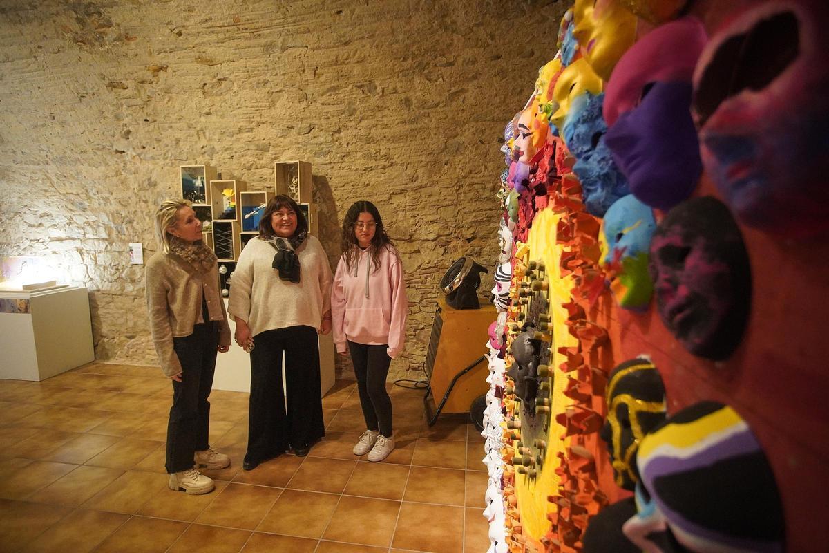 La psicòloga Glòria Tràfach, la directora del museu Carme Clusellas i Salima El Khlifi mirant una de les obres de la mostra