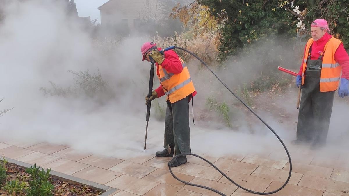 Varios trabajadores realizan labores de limpieza para eliminar pintadas en Alcañiz.