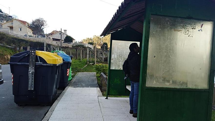 Contenedores ante una marquesina de autobús