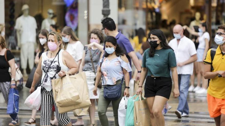 Los ciudadanos paseaban ayer por las calles de València con la mascarilla. | EDUARDO RIPOLL