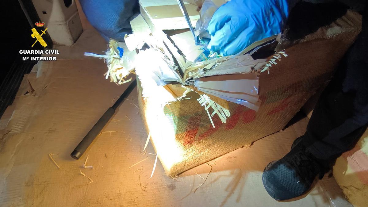 Un agente abre uno de los fardos de droga