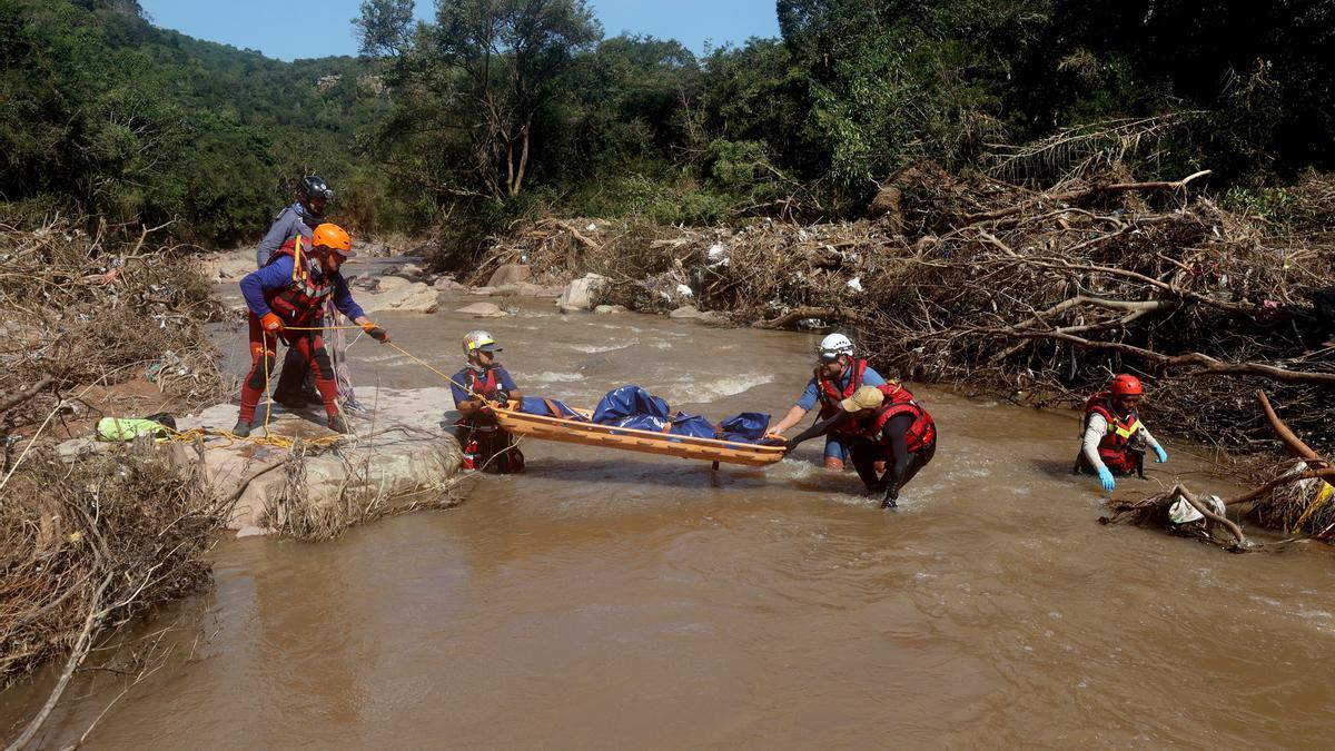 Un equipo de emergencias rescata el cadáver de una de las víctimas mortales de las inundaciones de Sudáfrica, este martes.