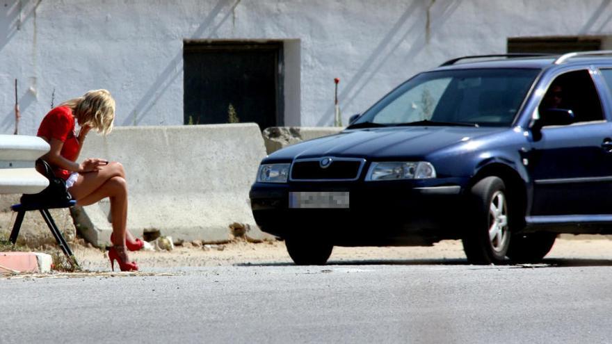 Una prostituta parant al peu de l&#039;N-II a les comarques gironines, amb un cotxe aturat al seu costat