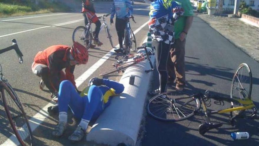 Uno de los ciclistas heridos, tendido junto a uno de los bloques que ocasionaron la caída.  // Álvaro Gómez