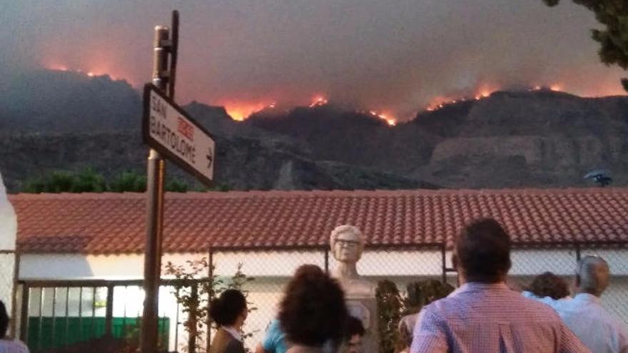 Vecinos de Santa Lucía observan el fuego en lo alto de la Cumbre.