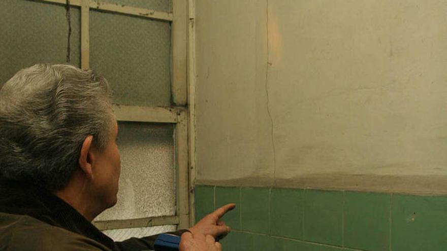 El dueño de un edificio contiguo a los desalojados muestra una grieta (izquierda), vecinos desalojados esperan para entrar en sus pisos (centro) e imagen de los dos edificios. / eduardo vicente
