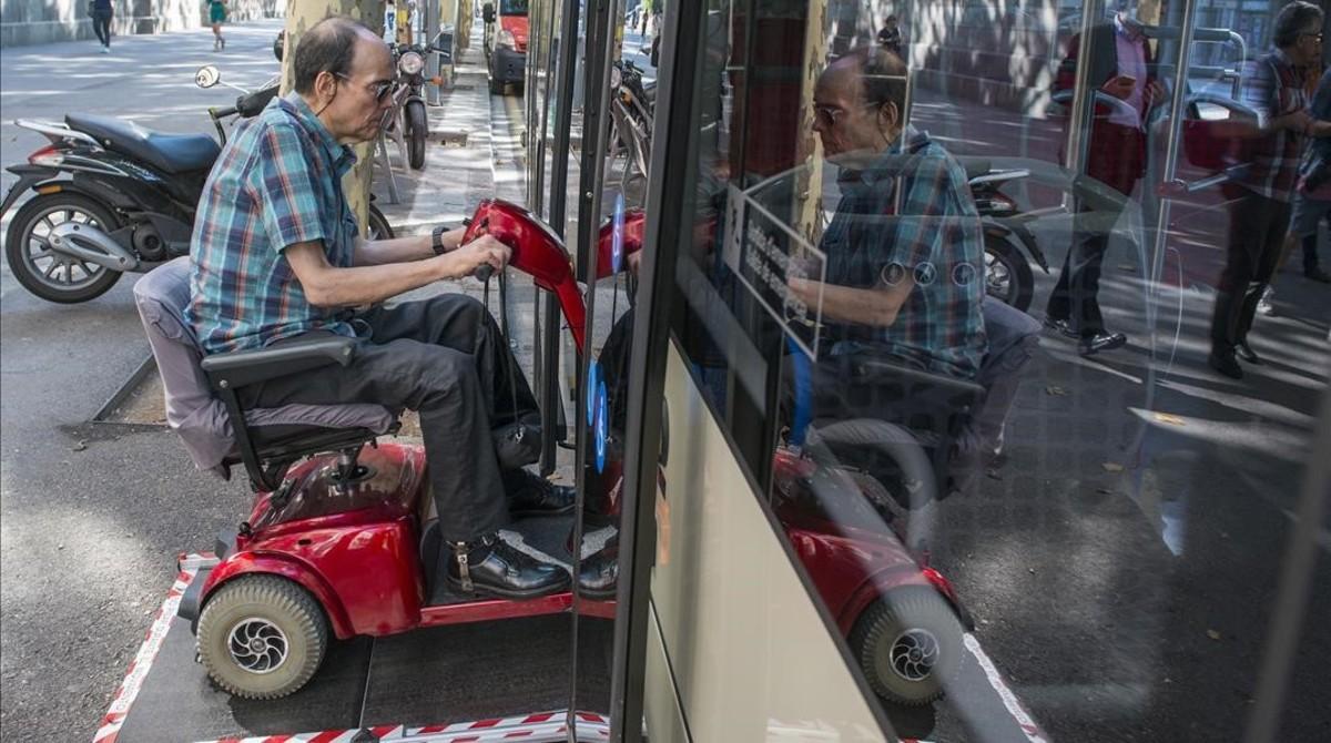 Una persona con movilidad reducida entra con su escúter en el bus.