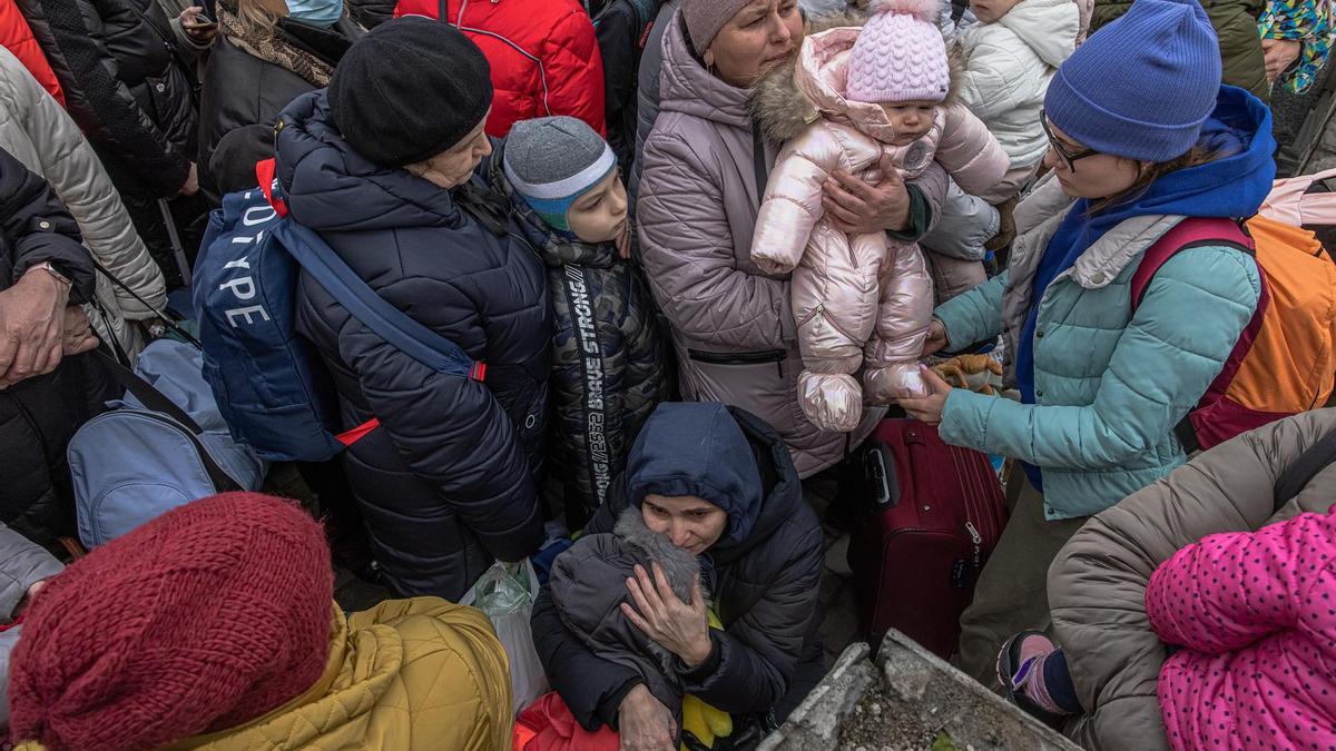 Una madre sostiene a su hijo mientras la gente espera un tren de evacuación a la ciudad de Kiev, en la estación de tren de Irpin. Mujeres y niños huyen de Bucha e Irpin, ciudades de primera línea de combates entre las fuerzas ucranianas y rusas.