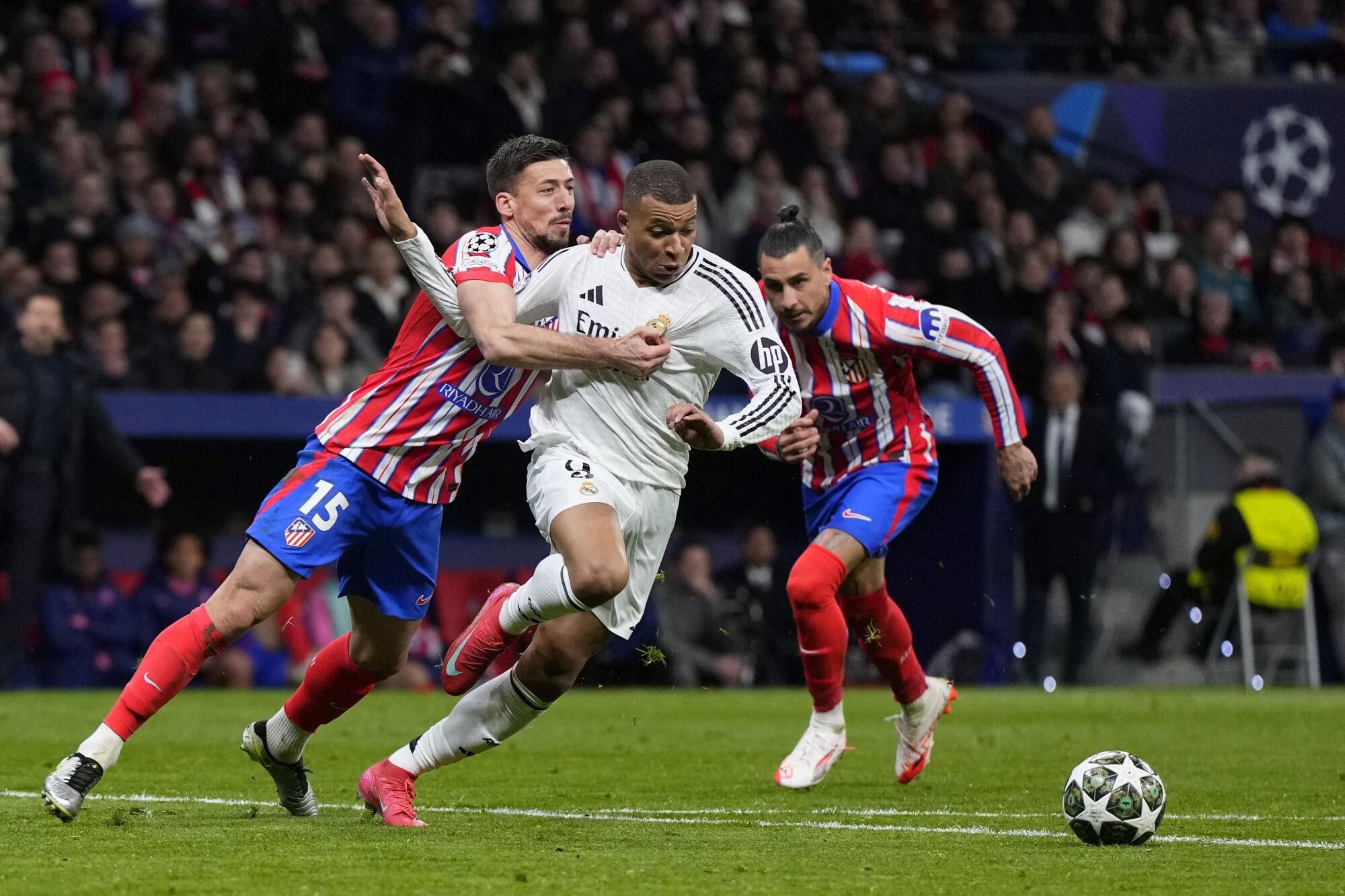 Atletico Madrid's Clement Lenglet, left, fouls Real Madrid's Kylian Mbappe during the Champions League round of 16, second leg, soccer match between Atletico Madrid and Real Madrid at the Metropolitano stadium in Madrid, Spain, Wednesday, March 12, 2025. (AP Photo/Manu Fernandez). EDITORIAL USE ONLY/ONLY ITALY AND SPAIN